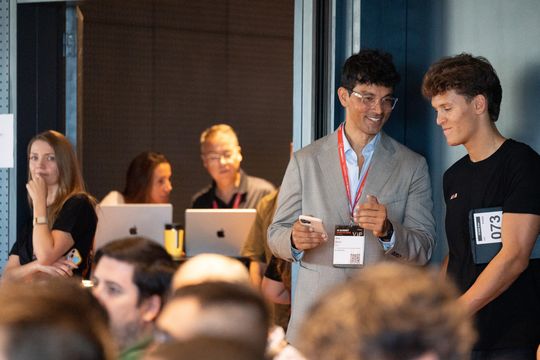 Sami with a founder between sessions, laptops open behind them